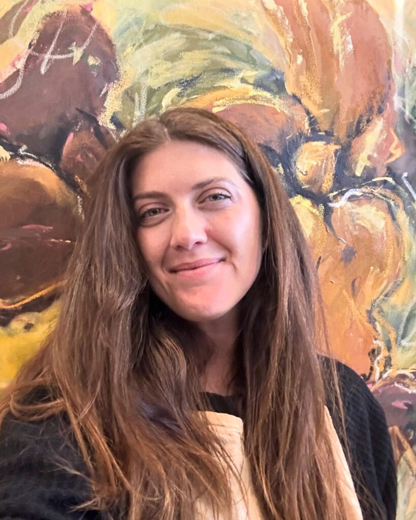 Retrato de la artista frente a una de sus pinturas.